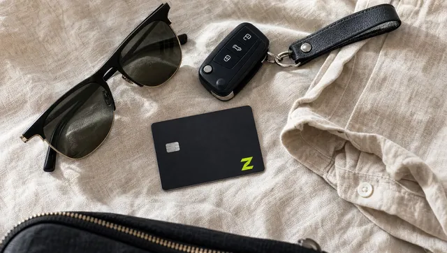 The ZERA card laid out with sunglasses, keys and a linen shirt.